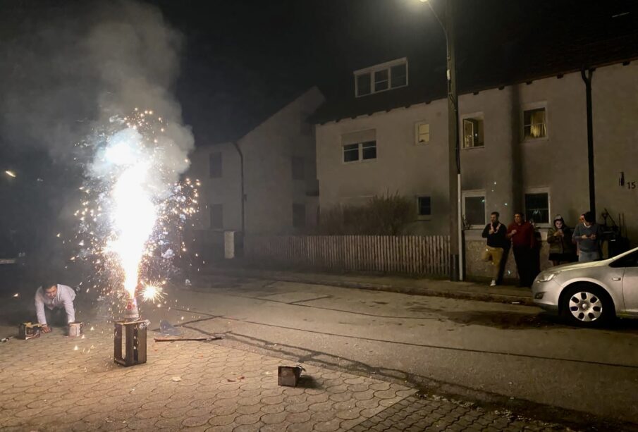 Una familia dando la bienvenida al Año Nuevo con la tradición de lanzar fuegos artificiales en Alemania.